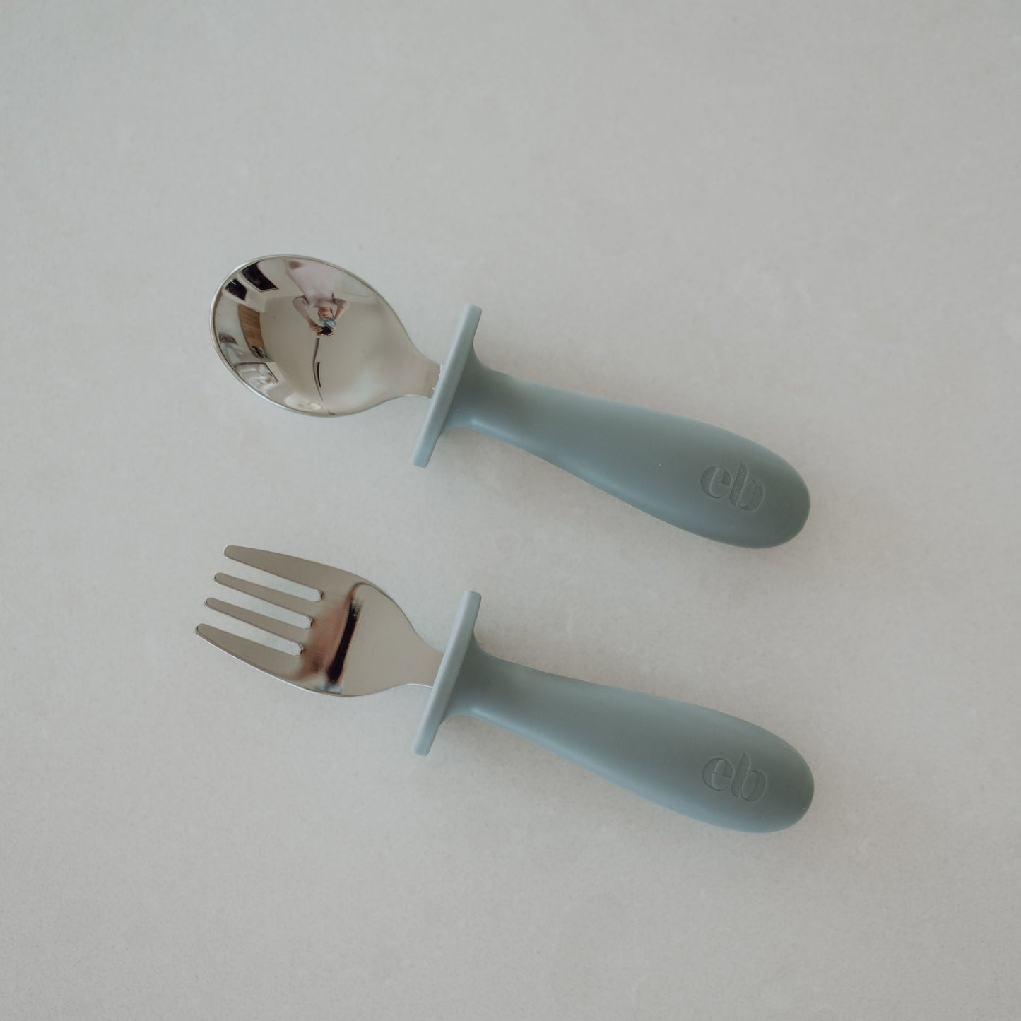 Children's spoon and fork set with blue handles on a white background