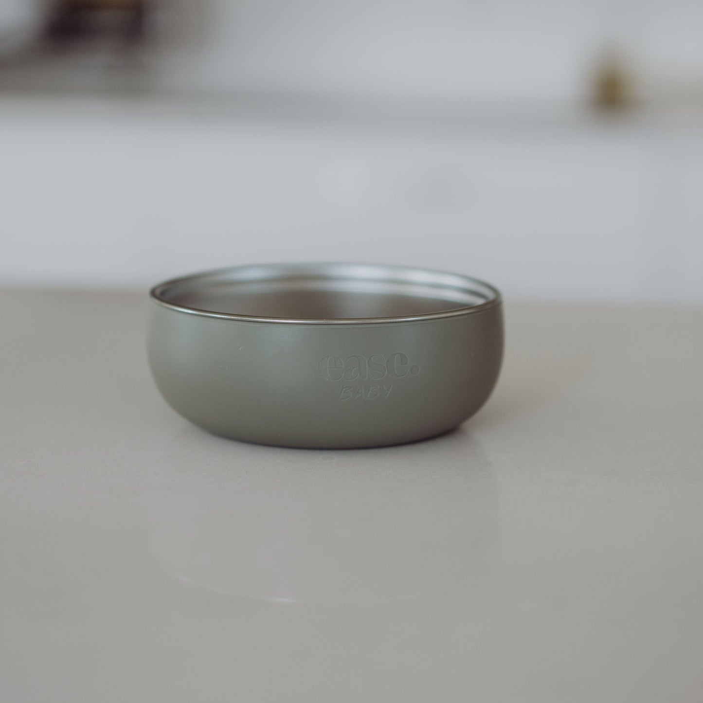 hunter Green Stainless Steel bowl on a light gray surface with a blurred background