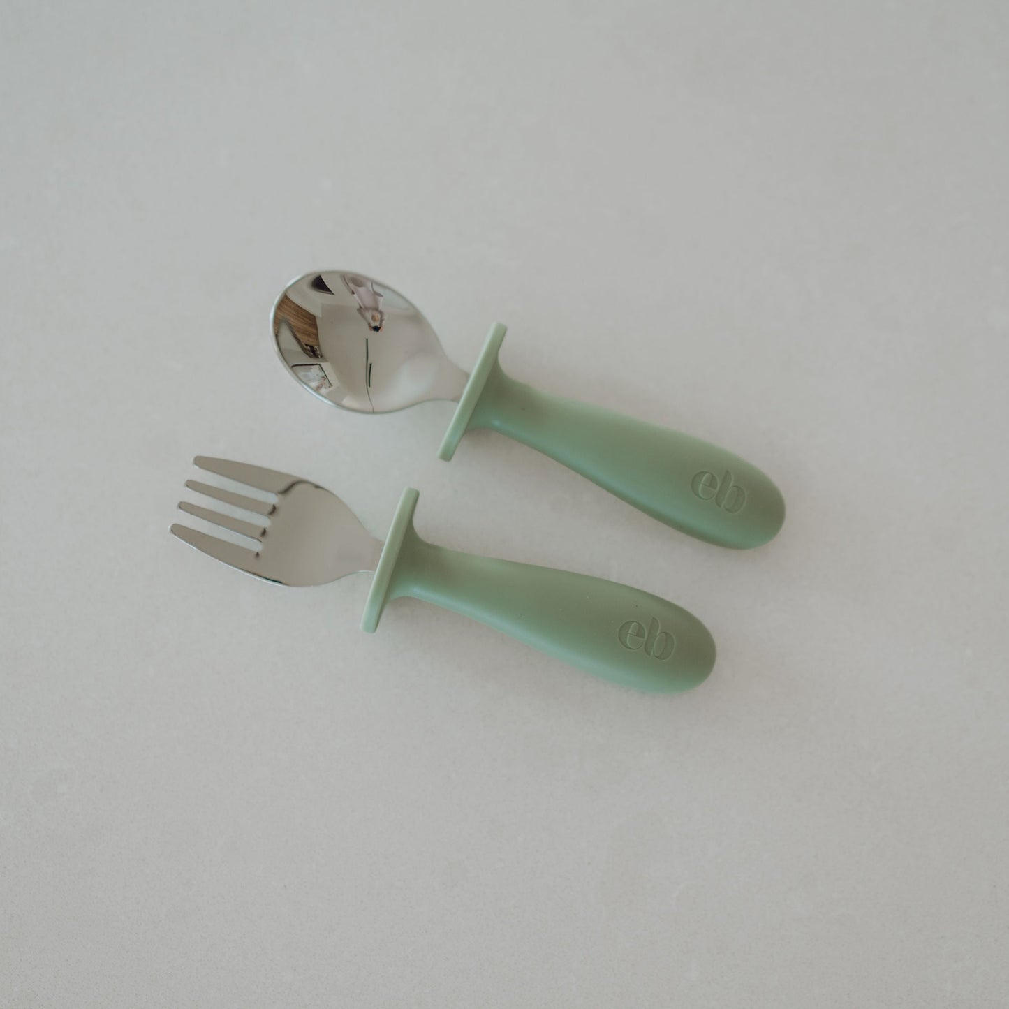 Mint green fork and spoon set on a white background