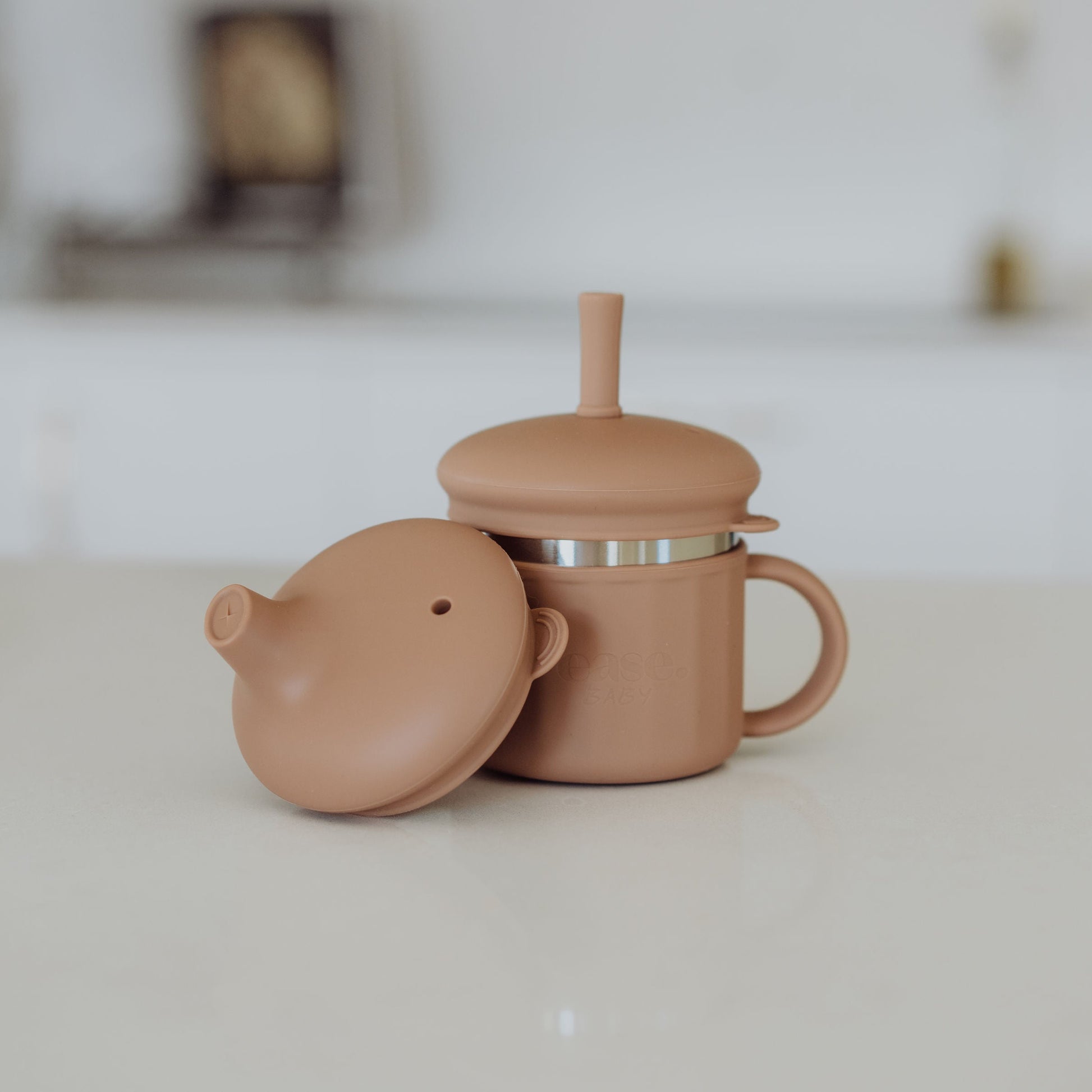Stainless Steel cup with sippy & straw lid on a white surface