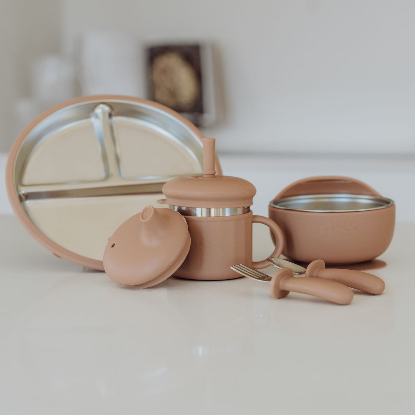 Set of pink silicone kitchen items including a lid, cup, and bowl on a white surface.
