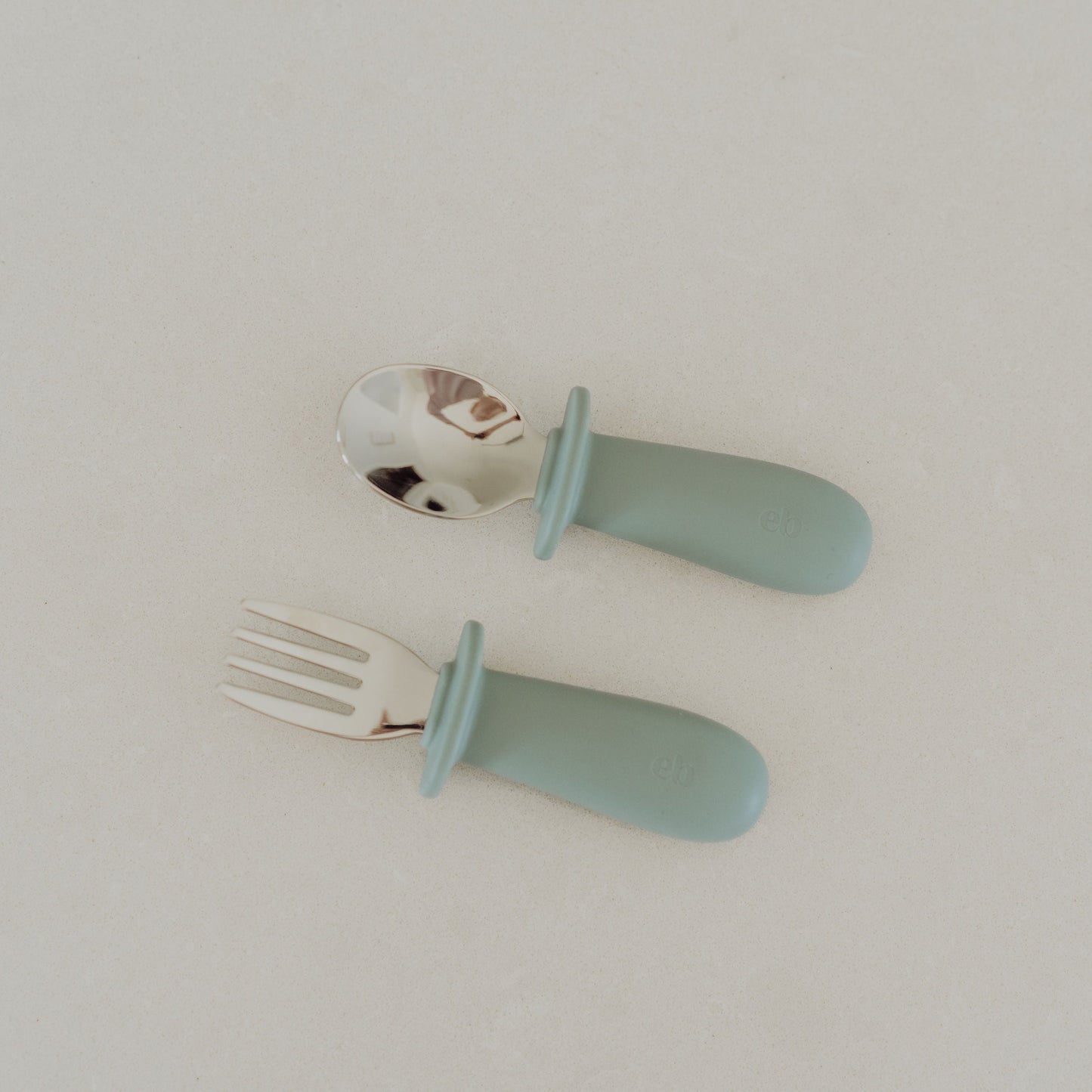Children's fork and spoon with light blue handles on a white background