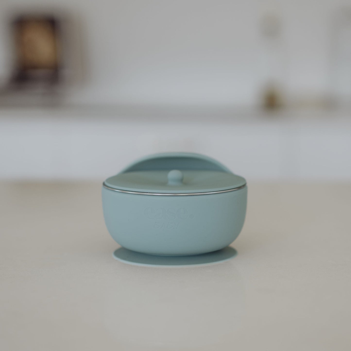 Light blue Stanless Steel bowl on a white surface with a blurred background